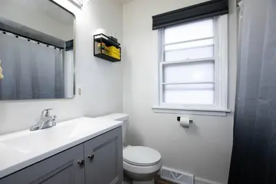 a bathroom with a sink and a toilet and a window at Yellow Harmony in South Euclid