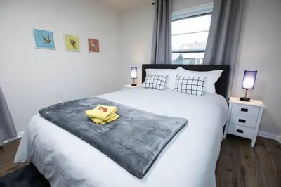 a bedroom with a large white bed with two lamps at Yellow Harmony in South Euclid