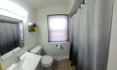 a bathroom with a sink and a toilet and a window at Yellow Harmony in South Euclid