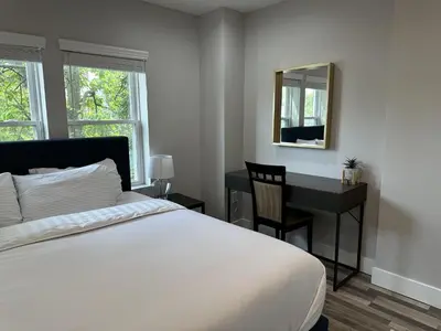a bedroom with a bed and a desk and a mirror at Cityscape 2BR Near Downtown in Columbus