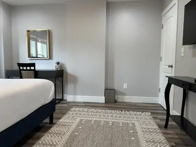 a bedroom with a bed and a desk and a mirror at Cityscape 2BR Near Downtown in Columbus