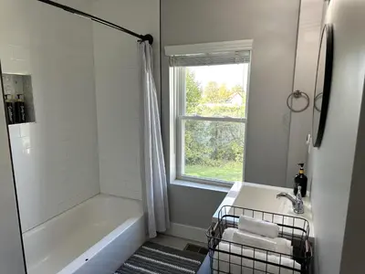a bathroom with a tub and a sink and a window at Cityscape 2BR Near Downtown in Columbus