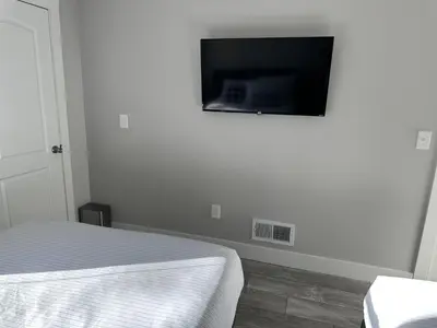 a bedroom with a bed and a flat screen tv on the wall at Cityscape 2BR Near Downtown in Columbus