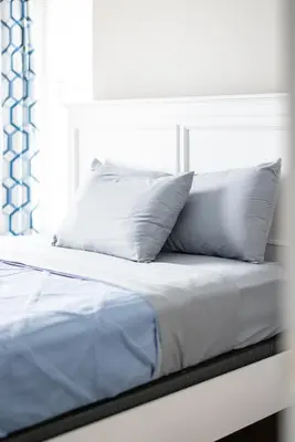 a white bed with two pillows and a window at Luxury Downtown Townhome Private Garage Unit 3 in Cleveland