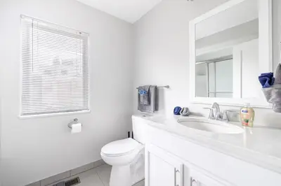 a white bathroom with a toilet and a sink at Luxury Downtown Townhome Private Garage Unit 3 in Cleveland