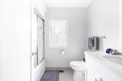 a white bathroom with a toilet and a sink at Luxury Downtown Townhome Private Garage Unit 4 in Cleveland