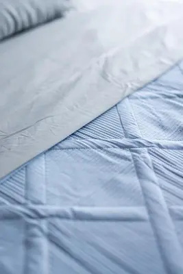 a close up of a bed with blue sheets at Luxury Downtown Townhome Private Garage Unit 4 in Cleveland