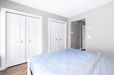 a white bedroom with a bed and two closets at Luxury Downtown Townhome Private Garage Unit 6 in Cleveland