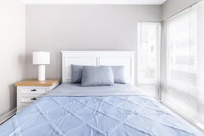 a white bedroom with a bed and a window at Luxury Downtown Townhome Private Garage Unit 6 in Cleveland