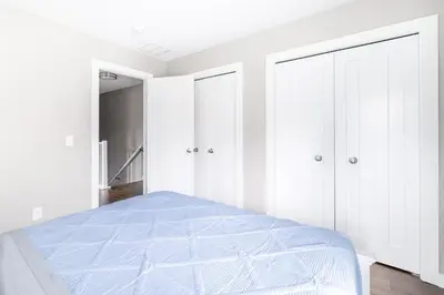 a white bedroom with a bed and white cabinets at Luxury Downtown Townhome Private Garage Unit 6 in Cleveland
