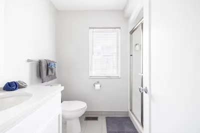 a white bathroom with a toilet and a sink at Luxury Downtown Townhome Private Garage Unit 10 in Cleveland