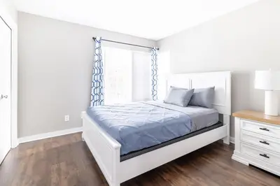 a white bedroom with a bed and a window at Luxury Downtown Townhome Private Garage Unit 10 in Cleveland