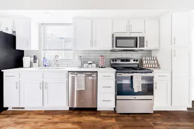 a white kitchen with a stove and a microwave at Luxury Downtown Townhome Private Garage Unit 10 in Cleveland