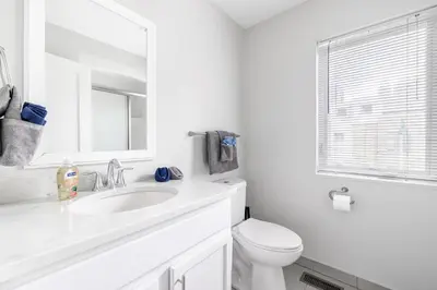 a white bathroom with a sink and a toilet at Luxury Downtown Townhome Private Garage Unit 10 in Cleveland