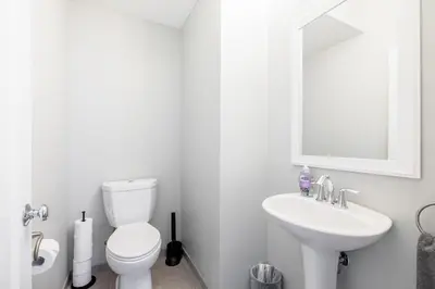 a white bathroom with a toilet and a sink at Luxury Downtown Townhome Private Garage Unit 11 in Cleveland