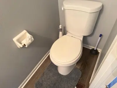 a white toilet in a bathroom with a broom at Private Cul-de-Sac Oasis 4BR in Grove City