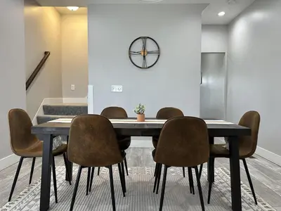 a dining room table with chairs and a clock on the wall at Urban Retreat 2BR Near Downtown in Columbus