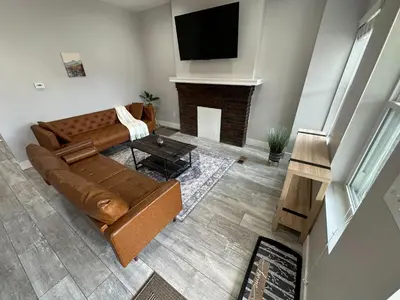 a living room with a brown couch and a fireplace at Urban Retreat 2BR Near Downtown in Columbus
