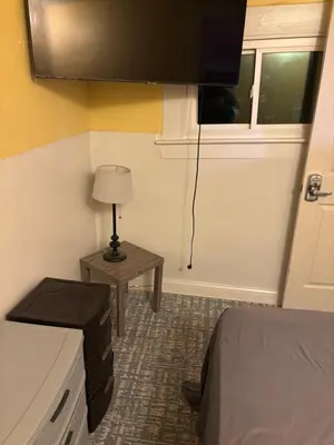 a room with a bed and a table with a lamp at Private tiny room for one in Cincinnati