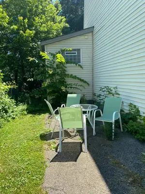 three chairs and a table in front of a house at Private tiny room for one in Cincinnati