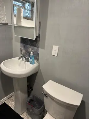a bathroom with a white toilet and a sink at Private tiny room for one in Cincinnati