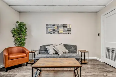 a living room with a couch and a chair at NEW Renovated Near CLE - King Bed, Metropark & Firepit in Berea