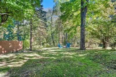 a person sitting on a bench in a park with trees at NEW Renovated Near CLE - King Bed, Metropark & Firepit in Berea