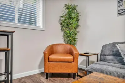 a living room with a chair and a couch at NEW Renovated Near CLE - King Bed, Metropark & Firepit in Berea