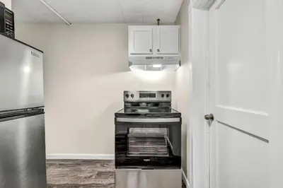 a kitchen with a stove and a refrigerator at NEW Renovated Near CLE - King Bed, Metropark & Firepit in Berea