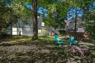 two chairs sitting in a yard in front of a house at NEW Renovated Near CLE - King Bed, Metropark & Firepit in Berea
