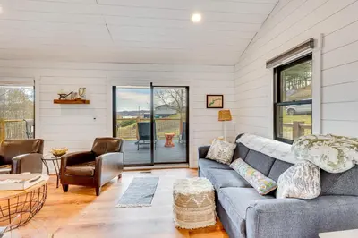 a living room with a couch and a table at 1 Mi to Marina Cabin with Views Near Atwood Lake! in Dellroy