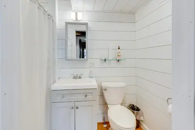 a white bathroom with a toilet and a sink at 1 Mi to Marina Cabin with Views Near Atwood Lake! in Dellroy