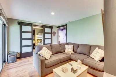 a living room with a couch and a table at 1 Mi to Marina Cabin with Views Near Atwood Lake! in Dellroy