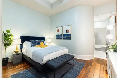 a bedroom with a bed with a blue headboard at Luxury 4BR - Washington Park - Walk Everywhere in Cincinnati