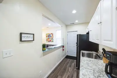 a kitchen with white cabinets and a black refrigerator at Charming Getaway on Ash St- Minutes from Cinci in Ludlow
