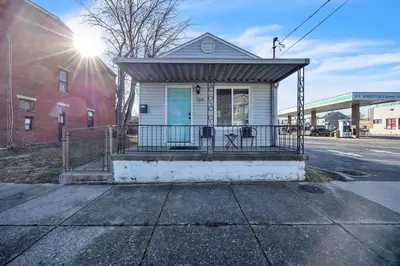 a small white house with a porch on a street at Charming Getaway on Ash St- Minutes from Cinci in Ludlow
