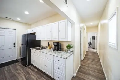 a kitchen with white cabinets and a black refrigerator at Charming Getaway on Ash St- Minutes from Cinci in Ludlow