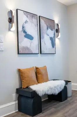 a living room with a bench and three paintings at Little Gem in Millersburg