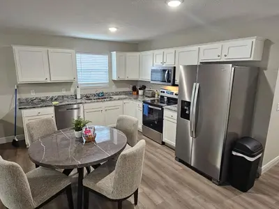 a kitchen with a table and a stainless steel refrigerator at Amazing New Wilmington Ranch in Wilmington