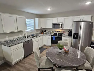 a kitchen with white cabinets and a table with chairs at Amazing New Wilmington Ranch in Wilmington