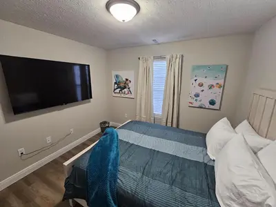 a bedroom with a bed and a flat screen tv at Amazing New Wilmington Ranch in Wilmington