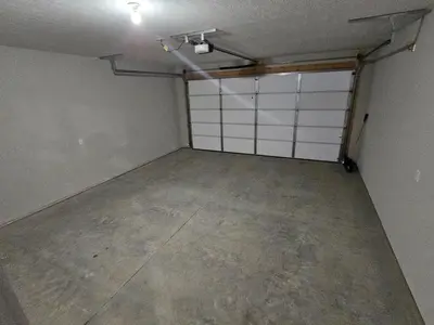 an empty garage with white doors and a concrete floor at Amazing New Wilmington Ranch in Wilmington