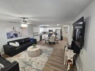 a living room with a black couch and a kitchen at Amazing New Wilmington Ranch in Wilmington