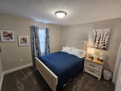 a bedroom with a blue bed and a window at Cute New Const Wilmington Ranch in Wilmington