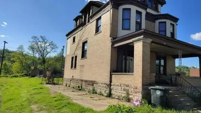 an old brick house with a grass yard in front of it at Valley and city views in Steubenville