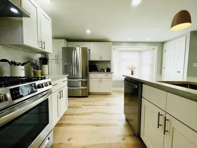 a kitchen with white cabinets and stainless steel appliances at Pink Bungalow Downtown in Sandusky