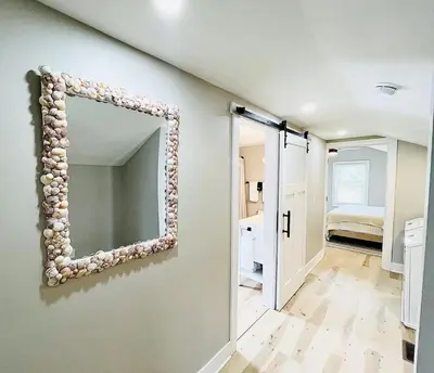 a mirror hanging on a wall in a room at Pink Bungalow Downtown in Sandusky