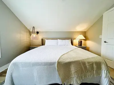 a bedroom with a large white bed with two lamps at Pink Bungalow Downtown in Sandusky