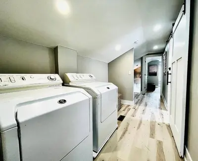 a laundry room with a washer and dryer in it at Pink Bungalow Downtown in Sandusky