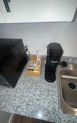 a box of donuts on a counter next to a blender at Bright & Cozy Near TQL & Paycor Stadiums in Cincinnati